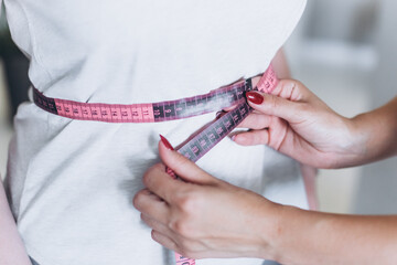 Young girl's waist is measured with a centimeter