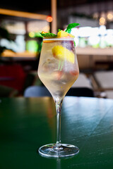 Mango and passion fruit cocktailwith mint. Delicious sweet fruit drink in a tall glass over green background.