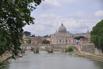 The Papal Basilica of Saint Peter behind Ponte Sant'Angelo on Tyber river, Rome, Italy - obrazy, fototapety, plakaty