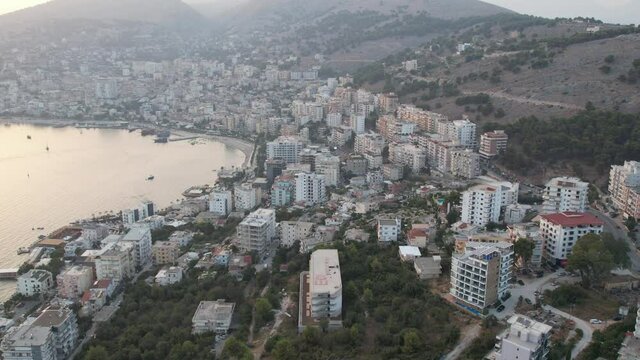 Aerial sunset drone view of Saranda city and port in Albania.