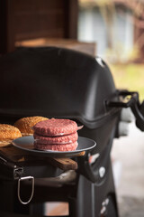Cooking classic beef burger on outdoor gas grill. Picnic in the garden.