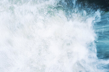 Fototapeta premium Fast flowing river close-up top view. Water movement. Turbulent stream texture motion blur. Beautiful abstract nature background