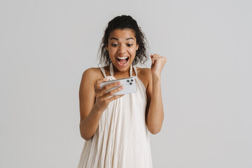 Black young woman playing online game on mobile phone