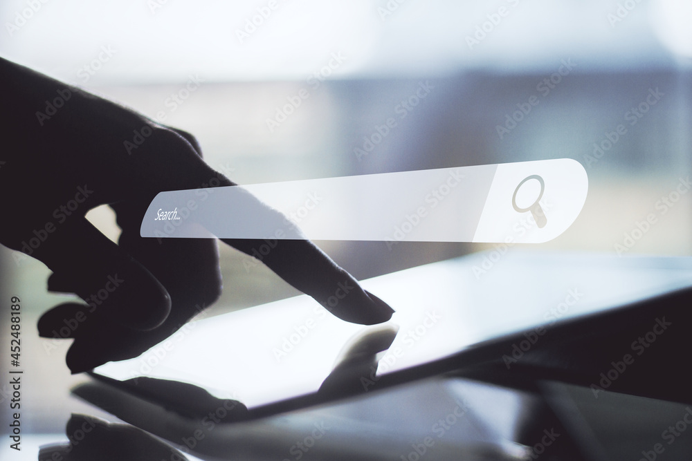 Poster Businessman hand holding tablet with creative website search bar hologram at desktop with blurry background. Internet and browse concept.