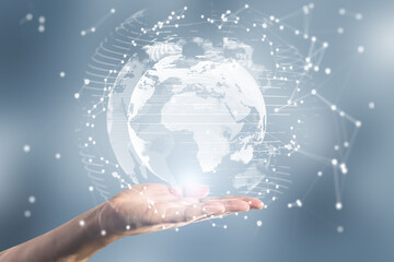 Close up of female hand holding abstract glowing polygonal globe on blurry background. Network,...