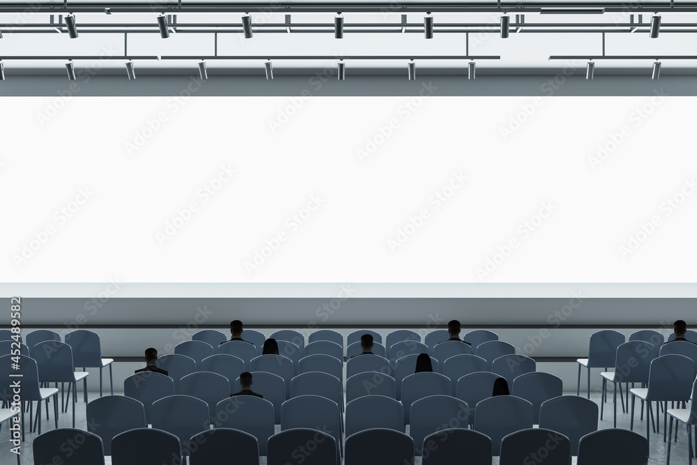 Poster people in contemporary grey auditorium with seating and empty screen with mock up place for your adv