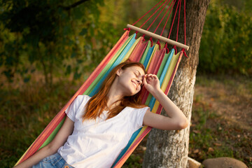 pretty woman lies in a hammock outdoors nature trees