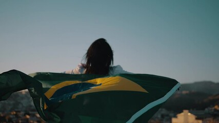 Black girl with Brazilian flag with city in the background.