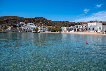 Fototapeta na wymiar Kimolos island Psathi village Cyclades Greece. Whitewashed buildings sandy beach calm blue sea