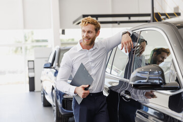 Man customer male buyer client wear white shirt hold clipboard with papers document lean on car...