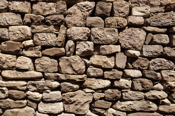Wall made from stones, ancient architecture to protect the house. A brick wall made from different bricks.