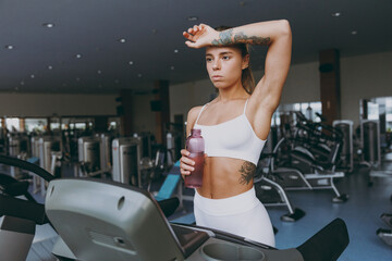 Young sweating skinny strong sporty athletic sportswoman woman in white sportswear warm up training...