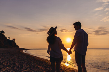 Back view silhouette young lovely couple two friends family man woman in summer clothes hold hands...
