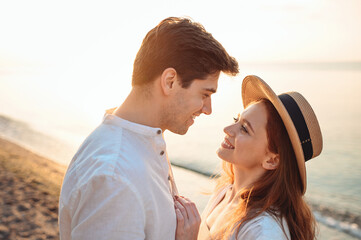 Close up profile young happy sunlit couple two friends family man woman in white clothes hug going to kiss together at sunrise over sea beach ocean outdoor exotic seaside in summer day sunset evening.
