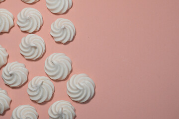 Closeup of french mini meringues cookies on dark blue as food background.