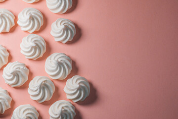 Fototapeta na wymiar Closeup of french mini meringues cookies on dark blue as food background.