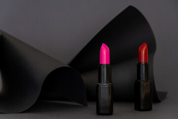 Art colourful geometry black style and make up cosmetics. Origami in a black colour and lipsticks in a red and pink. Paper mock up and luxury cosmetic. 