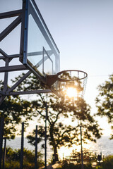 Sunlit sunshine modern outside empty basket hoop ring for playing basketball active game for american youth at outdoor court stadium in summer. Healthy urban lifetyle sport equipment playground