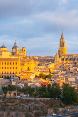 Cityscape in old city with colorful clouds at sunset; Cathedral and old town of Toledo, World Heritage Site, Spain. Close up vertical view