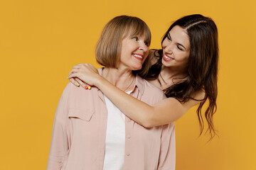 Two young smiling happy daughter mother together couple women wearing casual beige clothes looking...