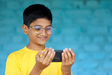 Cute Indian child using smartphone. online education concept