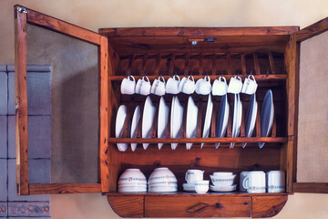 kitchen cupboard with doors open and plates, cups, bowls
