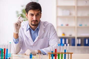 Young male chemist working at the lab