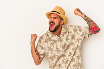 Young caucasian man with tattoos wearing summer clothes isolated on white background  raising fist after a victory, winner concept.