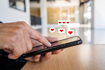 Man hand using smartphone with heart icon at office, He look message from lovers. Technology business and social lifestyle concept.