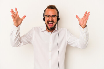 Young caucasian telemarketer man with tattoos isolated on white background  receiving a pleasant surprise, excited and raising hands.