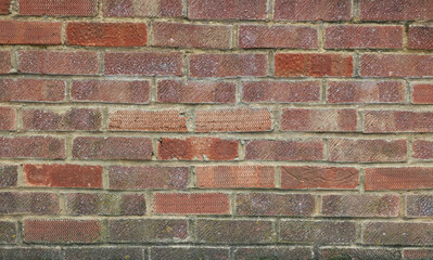 Old weathered brick wall in assorted coloured blocks with copy space