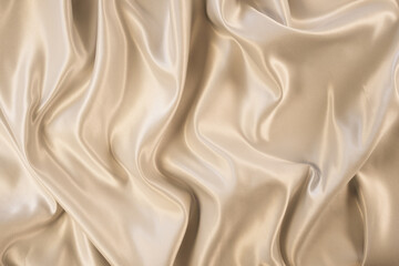 Photography of beautiful elegant wavy beige or light brown satin silk luxury cloth fabric texture,...