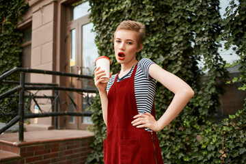 Fototapeta premium emotional woman with open mouth outdoors cup of drink lifestyle