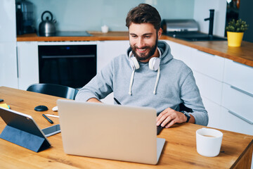 Smiling young graphic designer man working from home