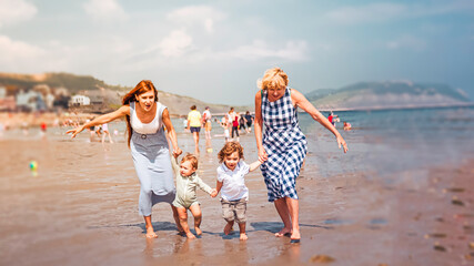 Multigenerational family is joyful and reunited during their summer holidyas in Lyme Regis, United Kingdom - obrazy, fototapety, plakaty