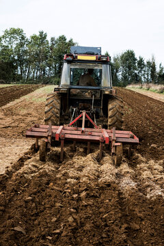 Rear view of tractor plowing a field on a farm.