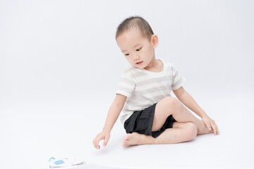 Naklejka premium A little asian boy takes a portrait in a white background shed