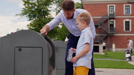 Father and son throwing out empty bottle to trash bin outdoors