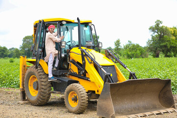 Indian man working with heavy equipment vehicle at construction site. - obrazy, fototapety, plakaty