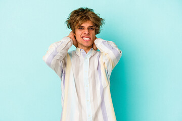Young caucasian man with make up isolated on blue background  screaming with rage.