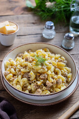 Pasta with minced meat and vegetables (navy) one portion on a wooden table