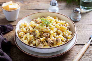 Pasta with minced meat and vegetables (navy) one portion on a wooden table