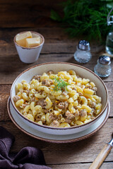 Pasta with minced meat and vegetables (navy) one portion on a wooden table