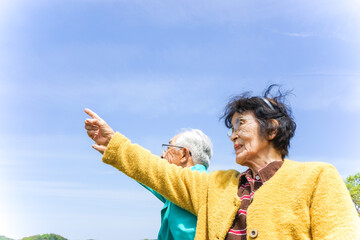 空を指差す高齢夫婦