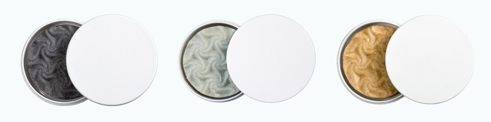 Pieces of round shampoo (soap) in black, gray and beige colors in a round plastic jar on a white background