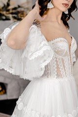 Fototapeta na wymiar A girl in the image of a bride in a white soho style dress