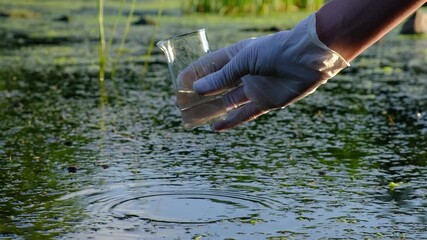 The hand holds a chemical flask with a liquid,