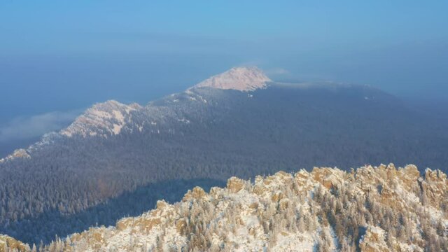 Snow-capped mountain ranges covered with coniferous forest. Taganay National Park in Russia. Aerial view