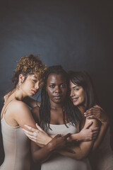 Three girls from different ethnicities posing in studio for a 