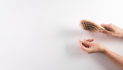 Healthcare problem concept. Woman hand holding hair loss or hair fall in comb on white background. - obrazy, fototapety, plakaty